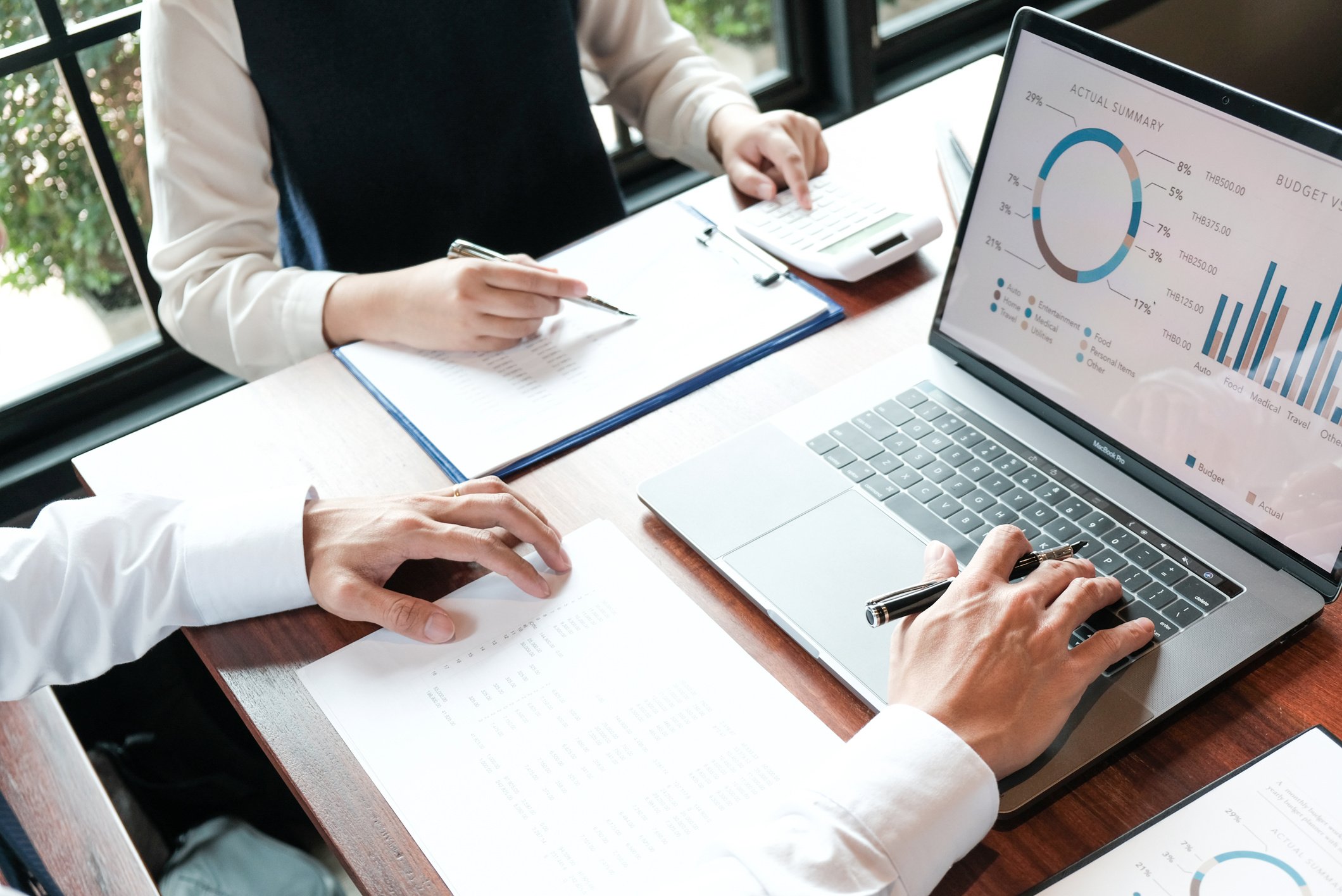 Businessman Analyzing Investment Charts and Pressing Calculator
